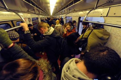 Москва. Пассажиры в вагоне поезда метро.
