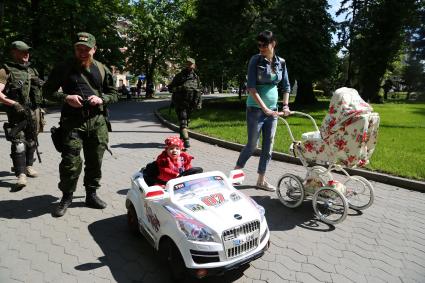 Украина, Донецк. Командир добровольческого батальона `Спарта` Арсений Павлов (Моторола) (второй слева) с женой Еленой и дочкой Мирославой на прогулке. На заднем плане в центре - охранник Гога.