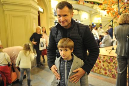 Москва.  Четырехкратный олимпийский чемпион по спортивной гимнастике, главный редактор журнала `Большой спорт` Алексей Немов с сыном Алексеем на открытии выставки детских рисунков по мотивам произведений Сергея Михалкова `Дяде Степе - 80` в ГУМе.