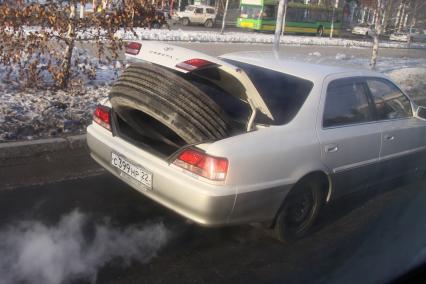 Барнаул.   Автомобильная шина в багажнике автомобиля.