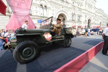 Москва.  Участник  на армейском автомобиле `Виллисе` (Willys MB) во время автопробега классических автомобилей `ГУМ-Авторалли` у ГУМа.