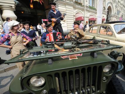 Москва.  Участники  на армейском автомобиле `Виллисе` (Willys MB) перед стартом автопробега  классических автомобилей `ГУМ-Авторалли` у ГУМа.