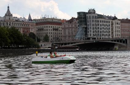 Чехия, Прага. Туристы катаются на катамаране. На заднем плане справа - `Танцующий дом`.