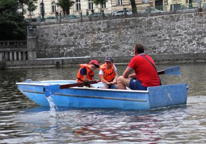 Чехия, Прага. Мужчина с мальчиками катаются на лодке.