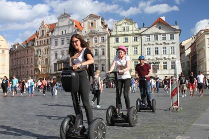 Чехия, Прага. Туристы катаются на сигвеях по Староместской площади.