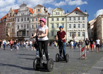 Чехия, Прага. Туристы катаются на сигвеях по Староместской площади.
