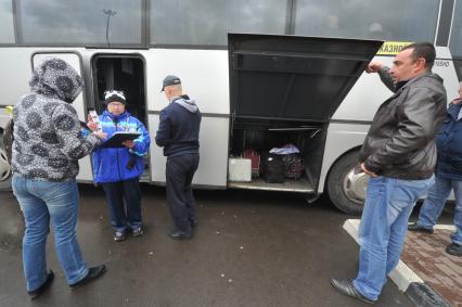 Москва. Кондуктор проверяет билет у пассажира перед отправлением автобуса у здания международного автовокзала `Южные ворота` в Люблино.
