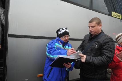 Москва. Кондуктор проверяет билет у пассажира перед отправлением автобуса у здания международного автовокзала `Южные ворота` в Люблино.
