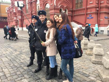 Москва. Девушки делают селфи с сотрудниками туристической полиции на Красной площади.