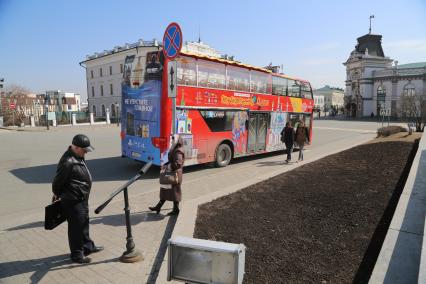 Казань.  Красный двухэтажный туристический автобус на одной из улиц города.