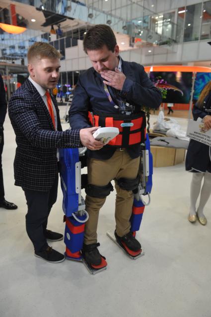 Москва. Корреспондент газеты `Комсомольская правда`Олег Адамович под руководством начальника конструкторского отдела Юго-Западного госуниверситета Олега Тарасова (слева) испытал медицинский экзоскелет на форуме `Открытые инновации-2016` в Сколково.