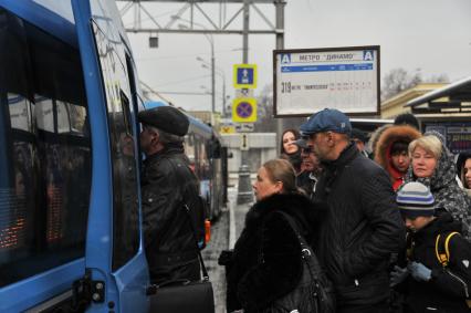 Москва.  Пассажиры садятся в автобус на остановке общественного транспорта `Метро `Динамо` на Ленинградском проспекте.