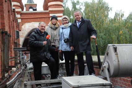 Москва. Корреспонденты `Комсомольской правды` Александр Гамов (слева), Наталия Андреассен (вторая справа), видеоператор Елизавета Совцова (вторая слева) и советник директора ФСО РФ Сергей Девятов на Кремлевской стене.