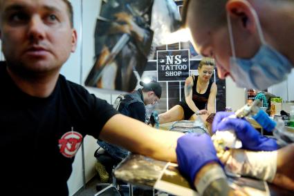 Екатеринбург. Уральский фестиваль искусства татуировки \'Ural tattoo convention 2016\'. Тату-мастера набивают татуировки посетителям фестиваля