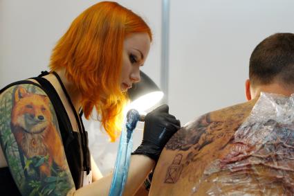 Екатеринбург. Уральский фестиваль искусства татуировки \'Ural tattoo convention 2016\'. Тату-мастер набивает татуировку посетителю фестиваля