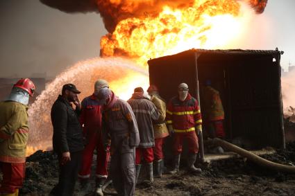 Ирак, Кайара. Пожарные заливают водой горящие нефтяные скважины, подожженные отступающими к Мосулу боевиками `Исламского Государства` (запрещенная в России экстремистская организация).