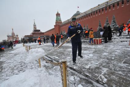 Москва.  Сотрудники коммунальных служб  убирают снег на Красной площади у Кремлевской стены.