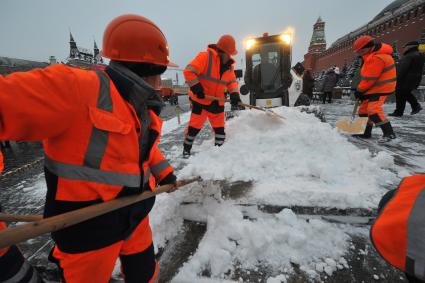 Москва.  Сотрудники коммунальных служб  убирают снег на Красной площади у Кремлевской стены.