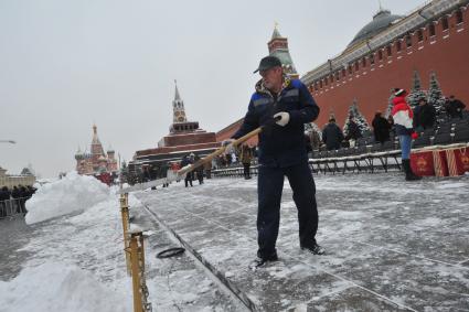 Москва. Сотрудники коммунальных служб убирают снег на Красной площади у Кремлевской стены.