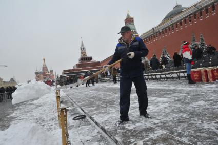 Москва.  Сотрудники коммунальных служб  убирают снег на Красной площади у Кремлевской стены.