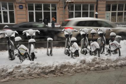 Москва.  Велосипеды под снегом на станции велопроката на улицах города.