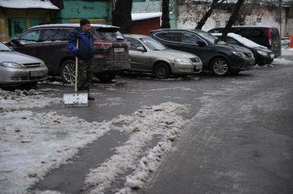 Москва. Дворник убирает снег с тротуара.