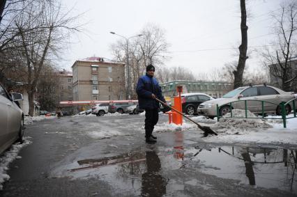 Москва. Дворник убирает снег с тротуара.