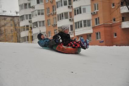 Москва.  Дети катаются с горки.