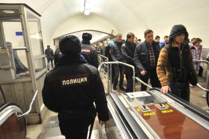 Москва. Сотрудники полиции на эскалаторе на станции метро `Октябрьская`.