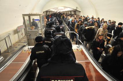 Москва.  Сотрудники полиции  на эскалаторе на станции метро `Октябрьская`.