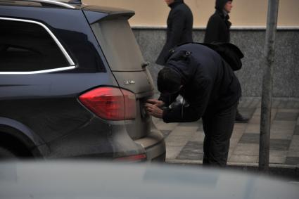 Москва. Мужчина закрывает номер автомобиля в зоне платной парковки в центре города.