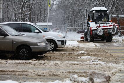 Ставрополь. Работник коммунальных служб на тракторе чистит дорогу от снега.