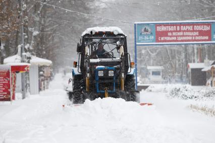 Ставрополь. Работник коммунальных служб на тракторе очищает дорогу от снега.