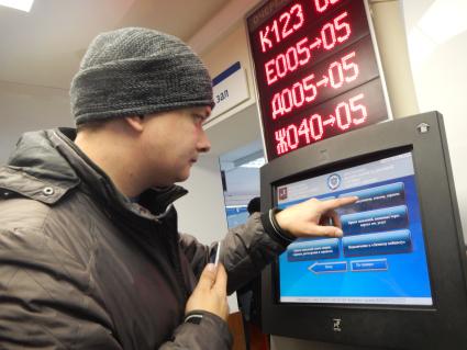 Москва. Корреспондент газеты `Комсомольская правда` Павел Клоков у терминала электронной очереди в налоговой инспекции.