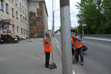 Калуга.  Работники коммунальных служб подметают улицу.