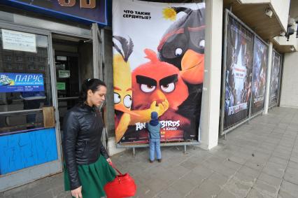 Калуга.  Мальчик у рекламного щита  фильма `Angry birds`.