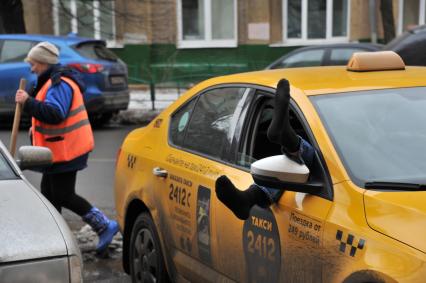 Москва.  Водитель такси отдыхает в автомобиле.