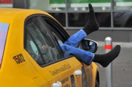 Москва.  Водитель такси отдыхает в автомобиле.