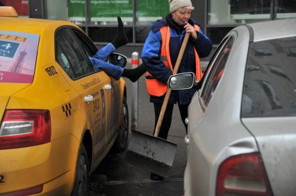 Москва.  Водитель такси отдыхает в автомобиле.