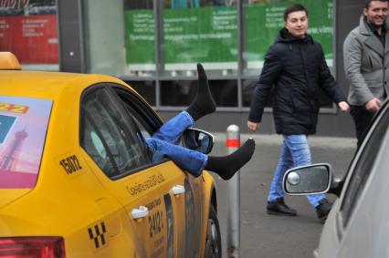 Москва.  Водитель такси отдыхает в автомобиле.