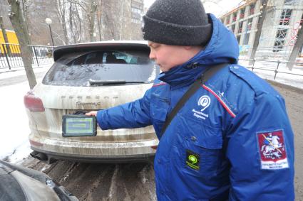 Москва. Пеший инспектор `Администрации московского парковочного пространства` проверяет оплату парковки.