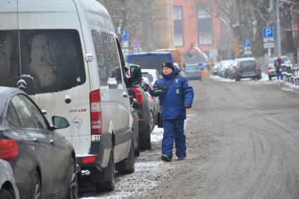 Москва. Пеший инспектор `Администрации московского парковочного пространства` проверяет оплату парковки.