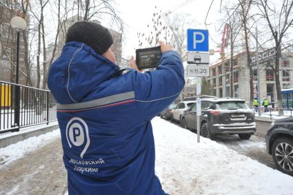 Москва. Пеший инспектор `Администрации московского парковочного пространства` проверяет оплату парковки.