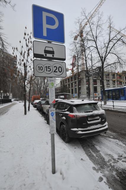 Москва. Пеший инспектор `Администрации московского парковочного пространства` проверяет оплату парковки.