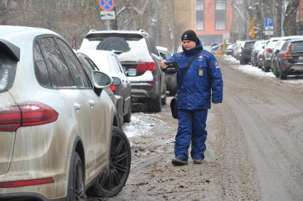 Москва. Пеший инспектор `Администрации московского парковочного пространства` проверяет оплату парковки.