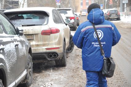 Москва. Пеший инспектор `Администрации московского парковочного пространства` проверяет оплату парковки.