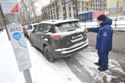 Москва. Пеший инспектор `Администрации московского парковочного пространства` проверяет оплату парковки.