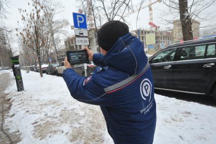 Москва. Пеший инспектор `Администрации московского парковочного пространства` проверяет оплату парковки.