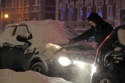 Уфа. Мужчина  очищает от снега автомобиль.