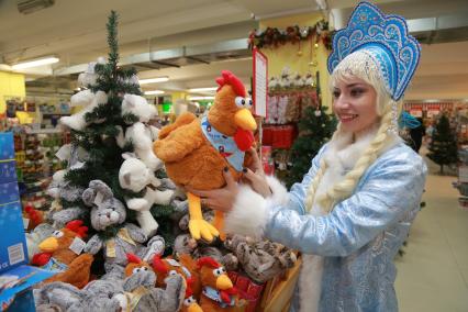Красноярск. Девушка в костюме Снегурочки выбирает мягкую игушку  в супермаркете.
